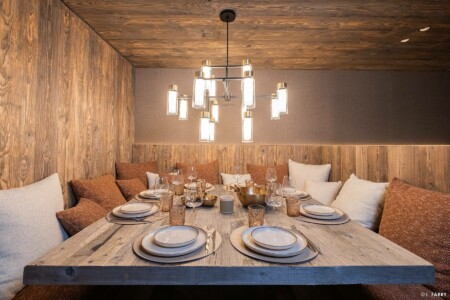 Photographie immobilière à Courchevel : table à manger d'un appartement dans le chalet le Manej