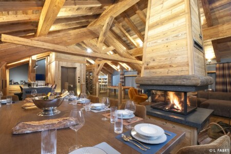 Chalet Kalinka : pièce de vie avec table dressée et cheminée allumée