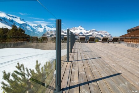 Grande terrasse du restaurant d'alpage baignée de soleil face au massif des Aravis