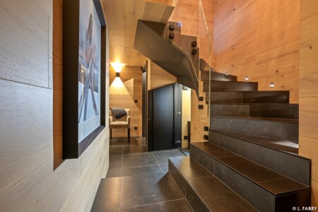 Chalet de luxe photographié à Megève : escalier vu depuis l'étage inférieur